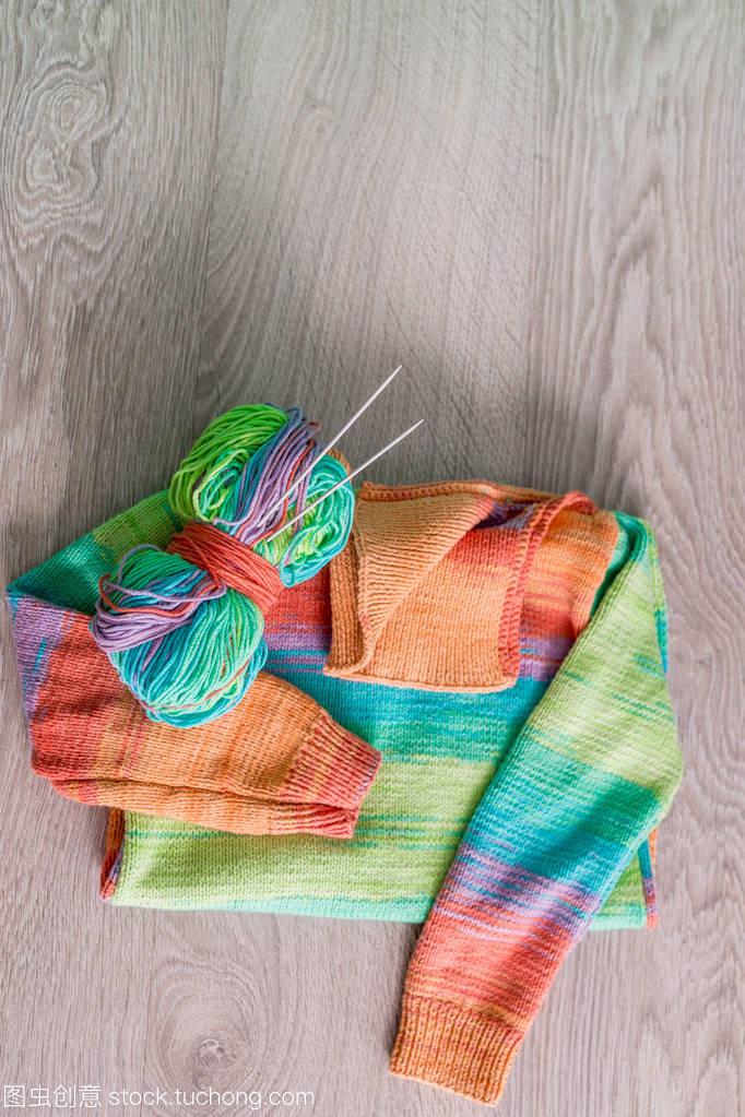 針織。針織毛衫。多色球的紗線用針附近上木制的灰色背景的手工產品。頂視圖。復制空間